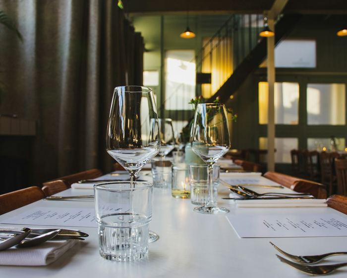 Restaurant table set with polished glassware and folded napkins before service